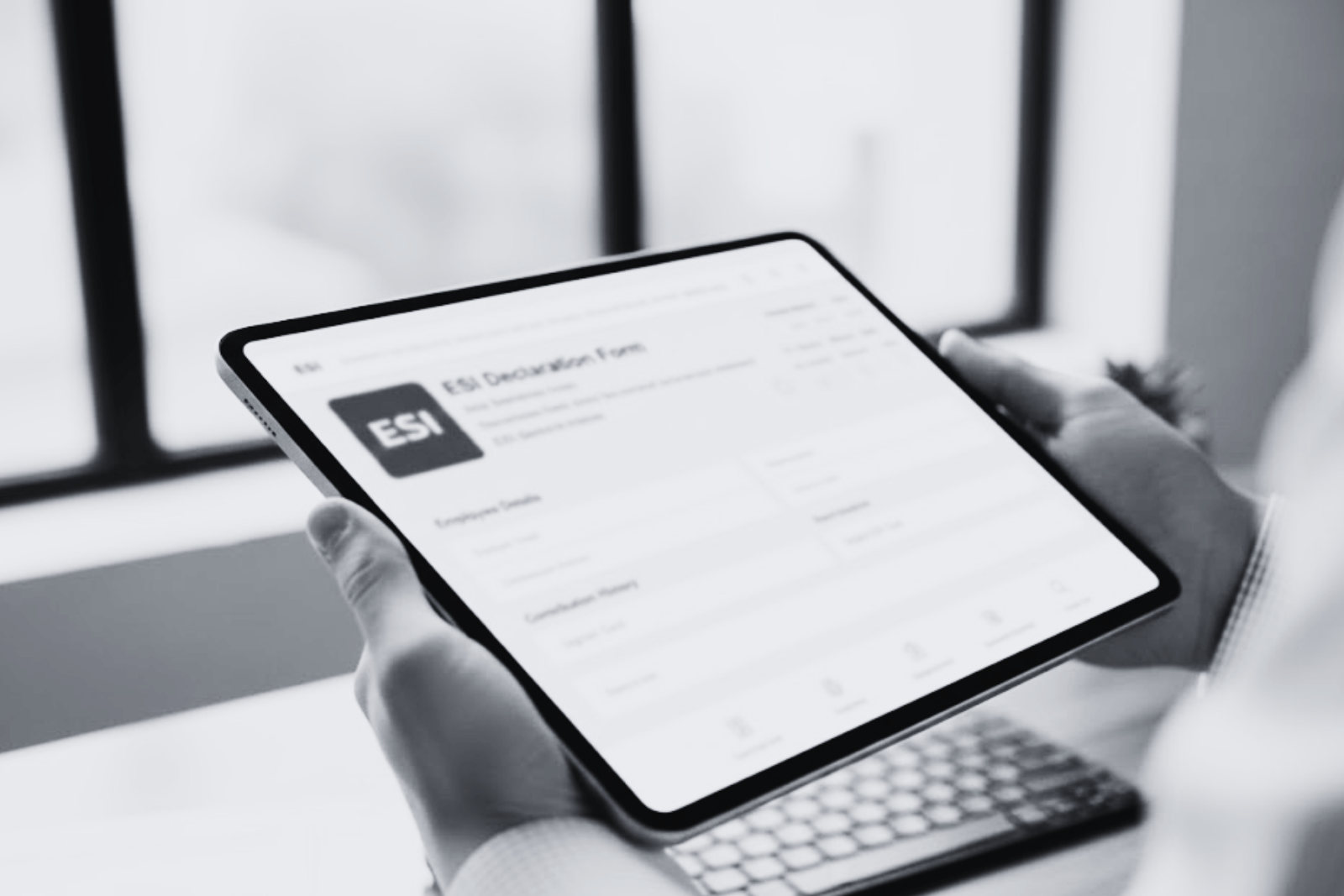 Hand holding ESI-related documents and digital forms on a tablet, representing PF ESI Consultant services in a professional workspace.