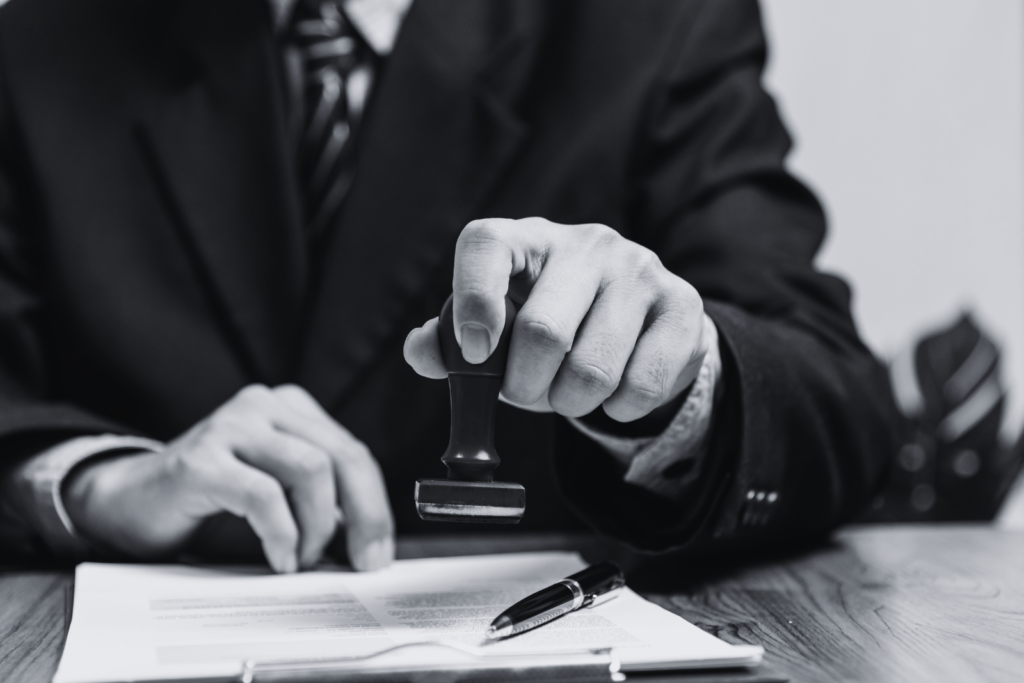 Documents stamped 'compliant' and 'approved' on a desk, representing Compliance Audit services in a professional corporate setting.